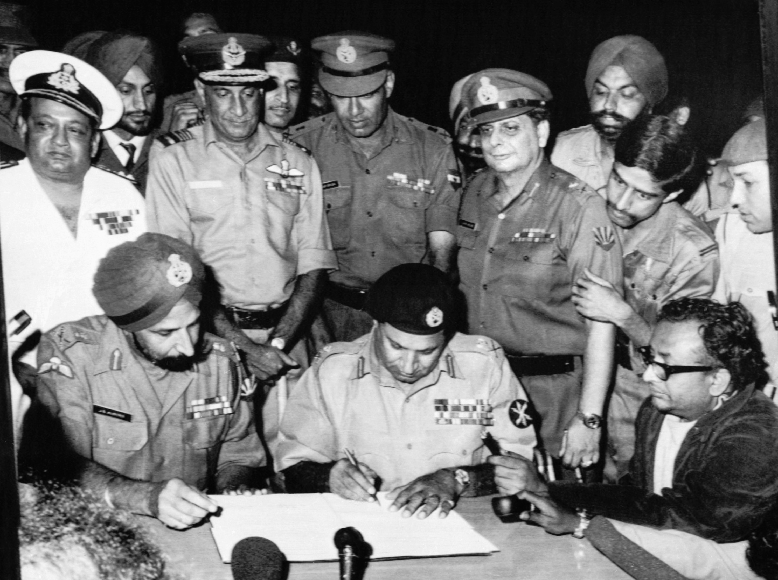 Pakistan's Lt. Gen. A. A. K. Niazi signing the instrument of surrender in Dhaka on 16 Dec' 1971, in the presence of India's Lt. Gen. J.S. Aurora. Standing behind them are officers of India's Army, Navy, and Air Force. The 1971 War directly involved participation of all three arms of the Indian Armed Forces.